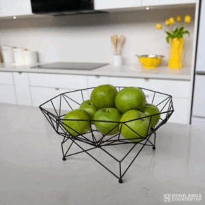 Fresh fruit displayed in a basket on sleek quartz kitchen countertop